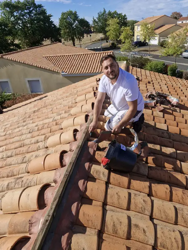 David Charpentier, artisan couvreur, au travail sur une toiture en tuiles